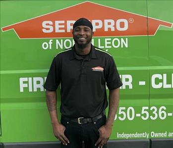 SERVPRO® crew member standing in front of a SERVPRO vehicle